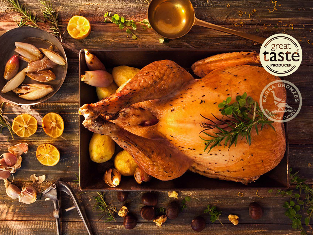 Roasted turkey on a tray with herbs and garnishes, rustic wooden background.