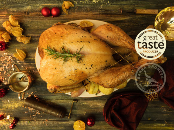 Roasted turkey on a plate with garnishes, surrounded by festive decorations and spices.