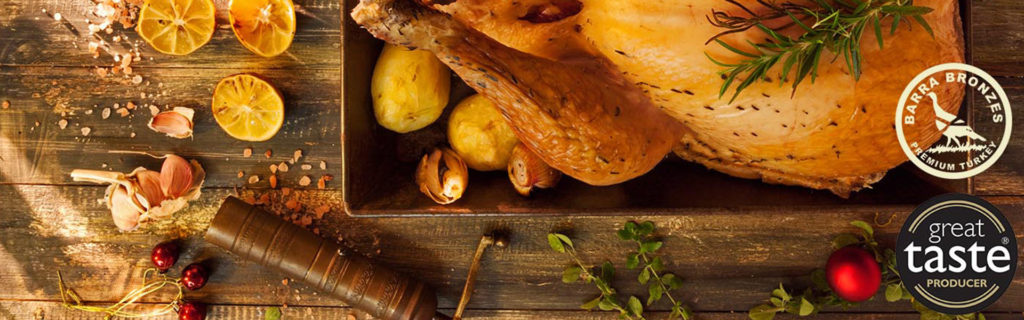 Roasted turkey with lemons and herbs on a rustic table with seasoning and awards badges.